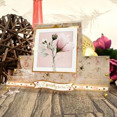 a card with flowers on it sitting next to some vases and other things in the background