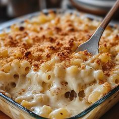 a casserole dish with macaroni and cheese in it on a wooden table