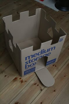 an open cardboard box sitting on top of a wooden floor