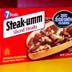 a box of steak - umm sliced steaks sits on a table in front of a red wall