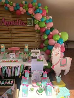 a birthday party with balloons, cake and desserts on the table for an alpaca themed baby shower