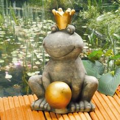 a frog statue sitting on top of a wooden platform