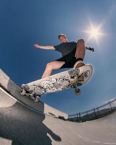 a man riding a skateboard up the side of a cement ramp at a skate park