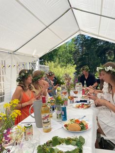 a group of people sitting around a table with food and drinks