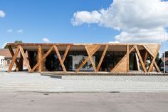 a building with wooden slats on the front and sides, against a cloudy blue sky