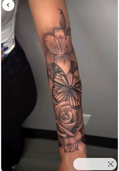 a woman's arm with flowers and a butterfly on it