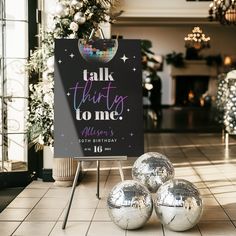 three shiny disco balls sitting in front of a sign that says talk thirty to me