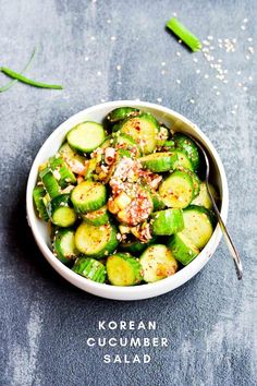 a white bowl filled with cucumbers and seasoning