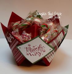 a red box filled with candy canes on top of a table