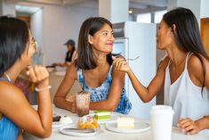 three women sitting at a table eating food