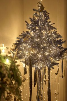 a christmas tree with lights and ribbons hanging from it