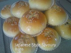 japanese style savory buns with sesame seeds are piled on top of each other