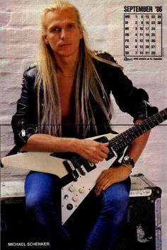 a man with long hair is holding a white guitar and posing for a magazine cover