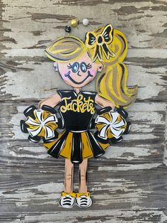 a cardboard cutout of a girl in a cheerleader outfit on a wooden background