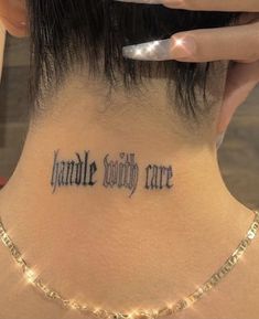 a woman with a tattoo on her neck that says handle society care written in cursive font