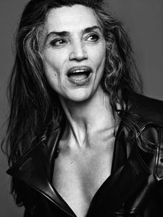 black and white photograph of woman in leather jacket with mouth wide open, looking surprised