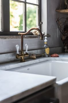 a kitchen sink with two faucets and soap dispensers