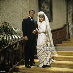 a bride and groom standing on the stairs