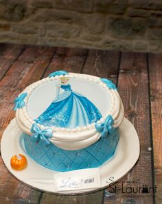 a blue and white cake sitting on top of a wooden table next to an orange