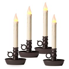 four lit candles are placed in small bowls with handles on each side and one candle is turned upside down