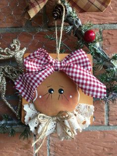 an ornament hanging on the side of a brick wall with a red and white checkered bow