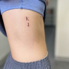 a woman's lower back tattoo with the letter k on her left ribcage