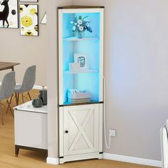 a white cabinet with blue lights in the corner next to a dining room table and chairs