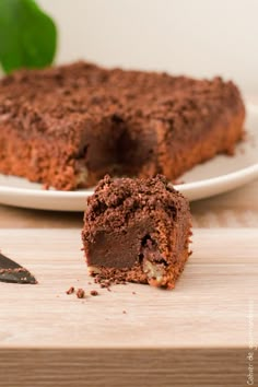 a piece of chocolate cake sitting on top of a white plate next to a knife