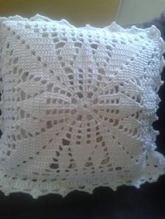 a white crocheted pillow sitting on top of a couch