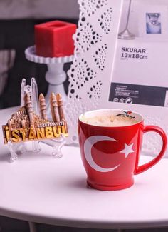 a cup of coffee sitting on top of a white table