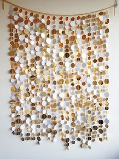 a wall hanging made out of different types of buttons and circles on a white wall