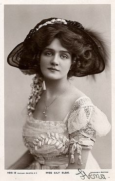 an old black and white photo of a woman in a dress with a large hat