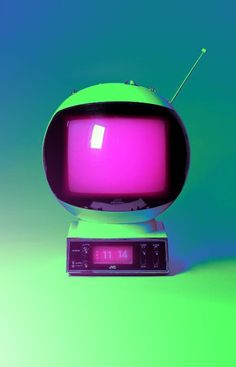 an old fashioned television set sitting on top of a green table with the screen lit up