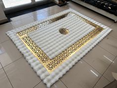 a white and gold area rug on the floor