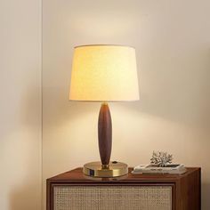 a lamp on top of a wooden table next to a radio