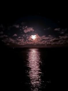 the full moon shines brightly in the night sky over the calm ocean water as it reflects on the surface of the water