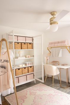 a white room with pink and gold accessories on shelves next to a bed, desk and chair