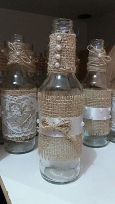 several bottles with burlap and lace on them