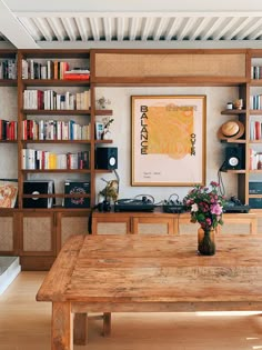 a wooden table sitting in front of a book shelf filled with books