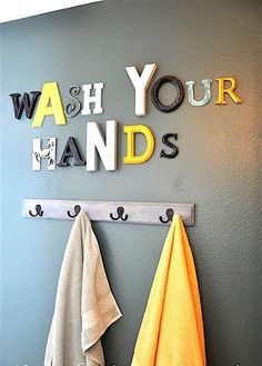 two towels hanging on a wall with the words wash your hands above them and below it