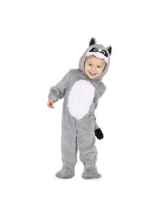 a toddler in a raccoon costume standing on one leg and smiling at the camera