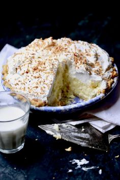 there is a pie on the table next to a glass of milk