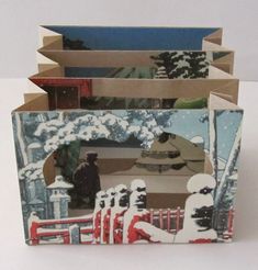 an open book with pictures of people in the snow and trees on it's cover