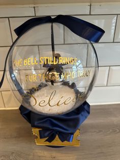 a snow globe with the words bell stillings for those to baby on it and a blue bow