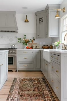 a large rug in the middle of a kitchen with gray cabinets and white counter tops