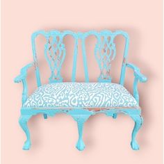 a blue bench sitting on top of a pink wall next to a white and blue chair