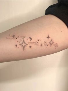 a woman's arm with stars and crescents on it, in black ink