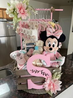 a minnie mouse themed baby gift basket on top of a kitchen counter with the number 3