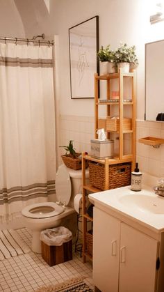 a bathroom with a toilet, sink, and shower curtain is shown in this image