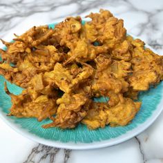 a blue plate topped with fried food on top of a marble counter